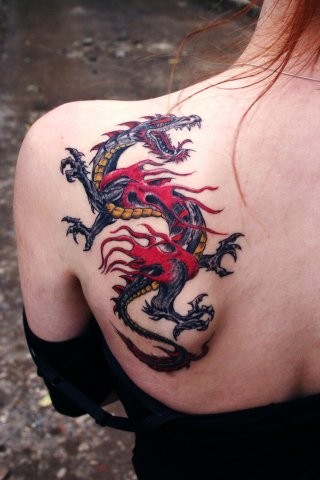Tatuaggio colorato sulla spalla il dragone con la bocca spalancata