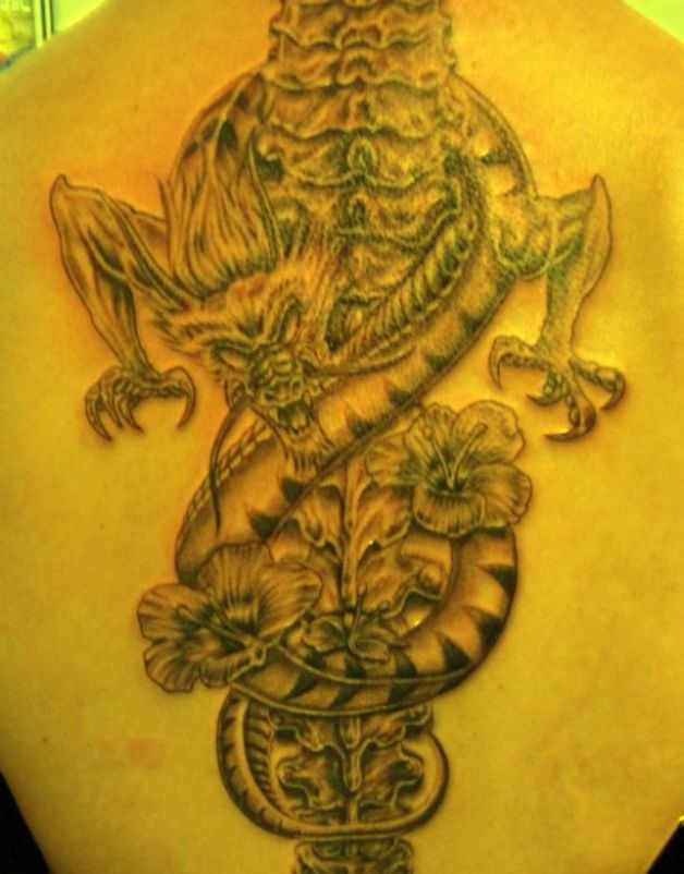 Tatuaje en la espalda, dragón retorcido alrededor de la columna vertebral