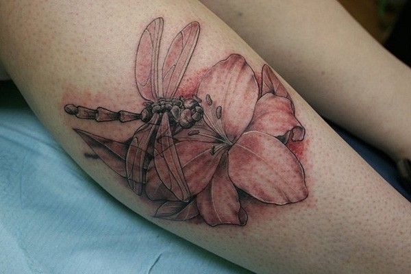 Dragonfly sitting on a flower tattoo