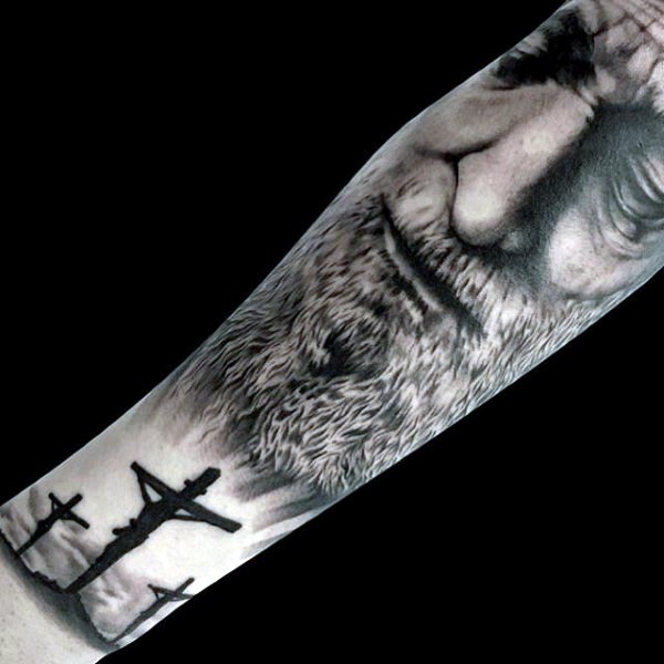Dramatic black ink forearm tattoo of sad man portrait