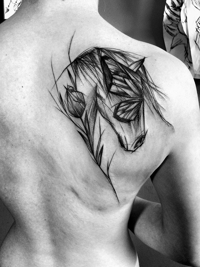 Estilo blackwork dramático desenhado por Inez Janiak tatuagem escapular de cavalo com flor