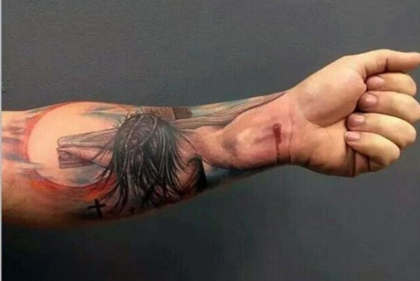 Dramatic colored religious themed forearm tattoo of Jesus on cross