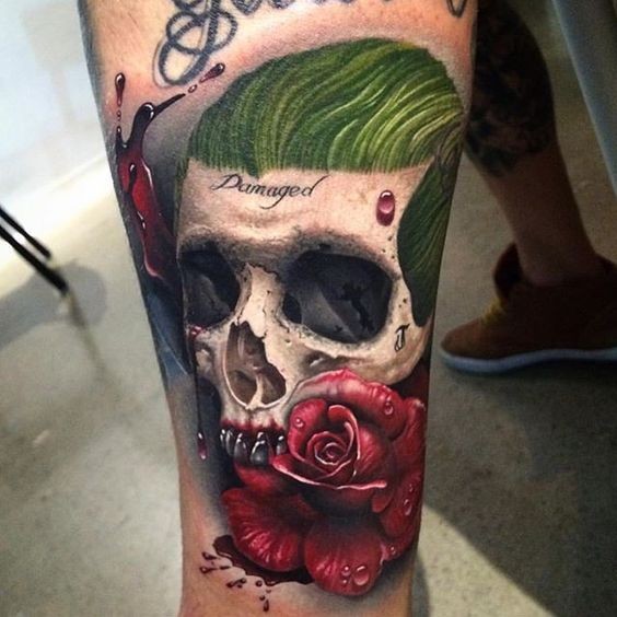 Dramatic colored tattoo of human skull with roses and lettering