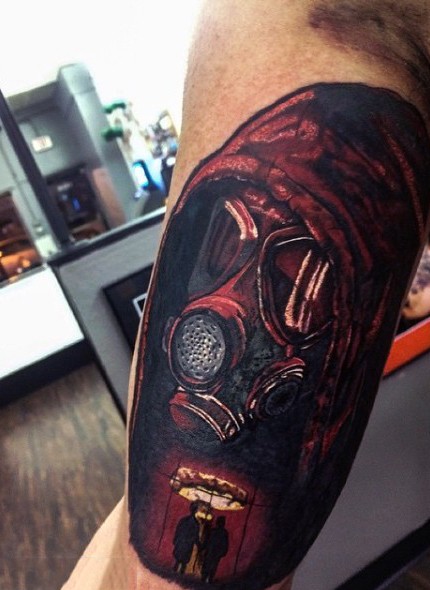 Dramatic illustrative style colored mad in gas mask tattoo on arm stylized with nuclear blast