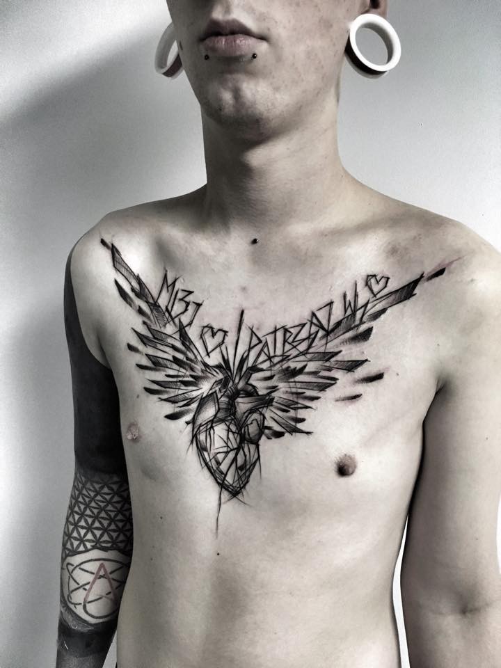 Tatuaje de aspecto dramático con tinta negra en el pecho del corazón humano con alas y letras