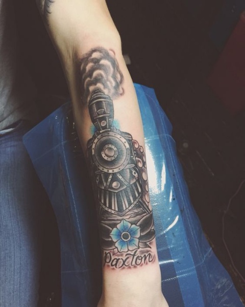Dramatic memorial colored arm tattoo of train with flower and lettering