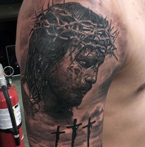 Dramatic religious themed shoulder tattoo of Jesus portrait