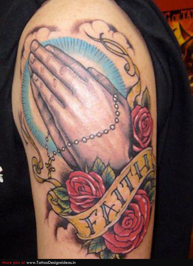drammatico stile disegno colorato mani pregano con rosario con nimbo e rose tatuaggio su spalla