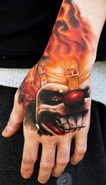 Dreadful clown in fire tattoo on hand by Kyle Cotterman