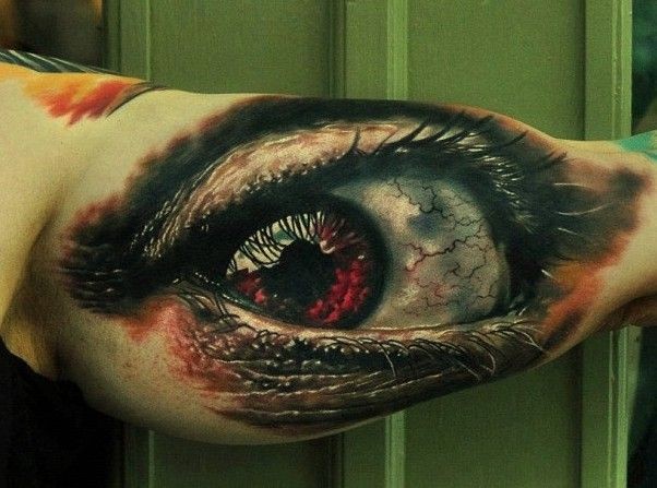 Tatuaje en el brazo de un ojo rojo terrible.