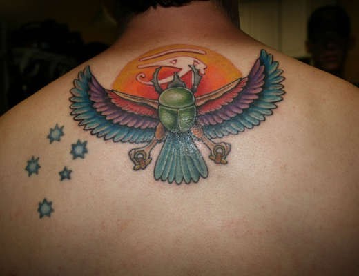 Egypt themed colorful mystical bird tattoo on upper back combined with stars
