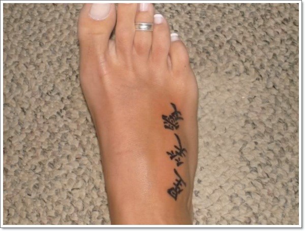 Elegante schwarze chinesische Hieroglyphen Tattoo am Fuß