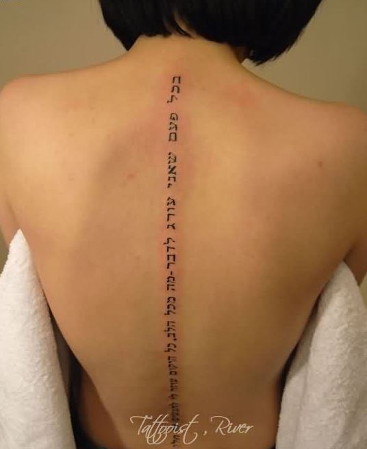 Elegant black hebrew lettering tattoo on back