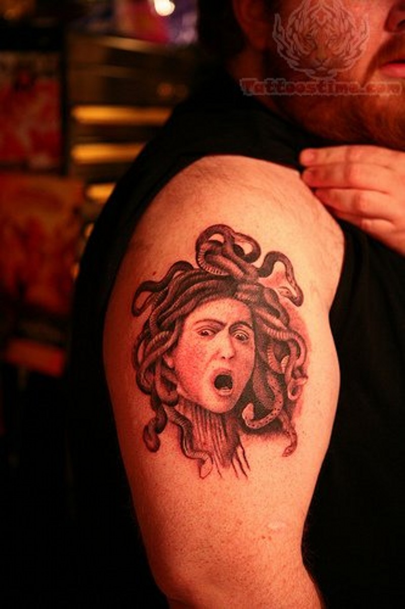 Engraving like black ink shoulder tattoo of small Medusa head