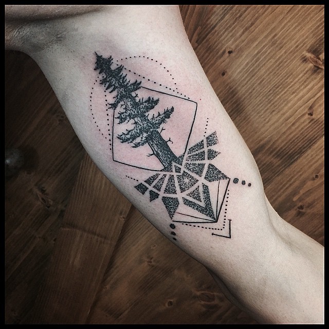 Engraving style black and white biceps tattoo of tree with geometrical symbols