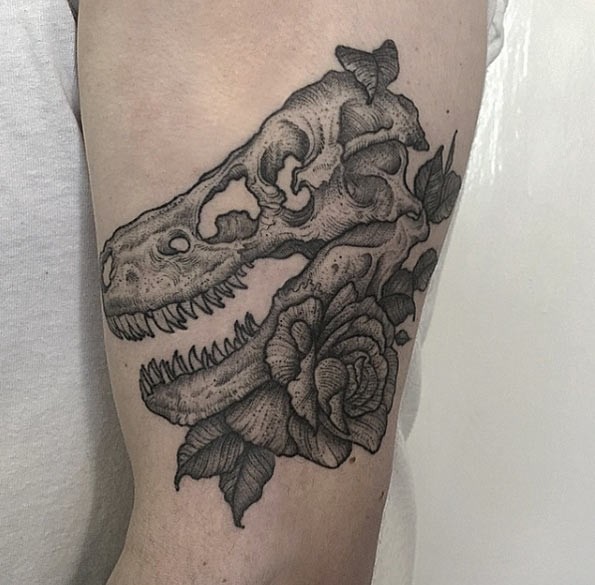 Engraving style black ink arm tattoo of dinosaur skeleton and rose