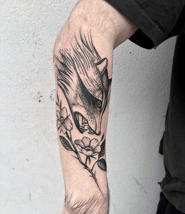 Engraving style black ink arm tattoo of evil raccoon with flowers
