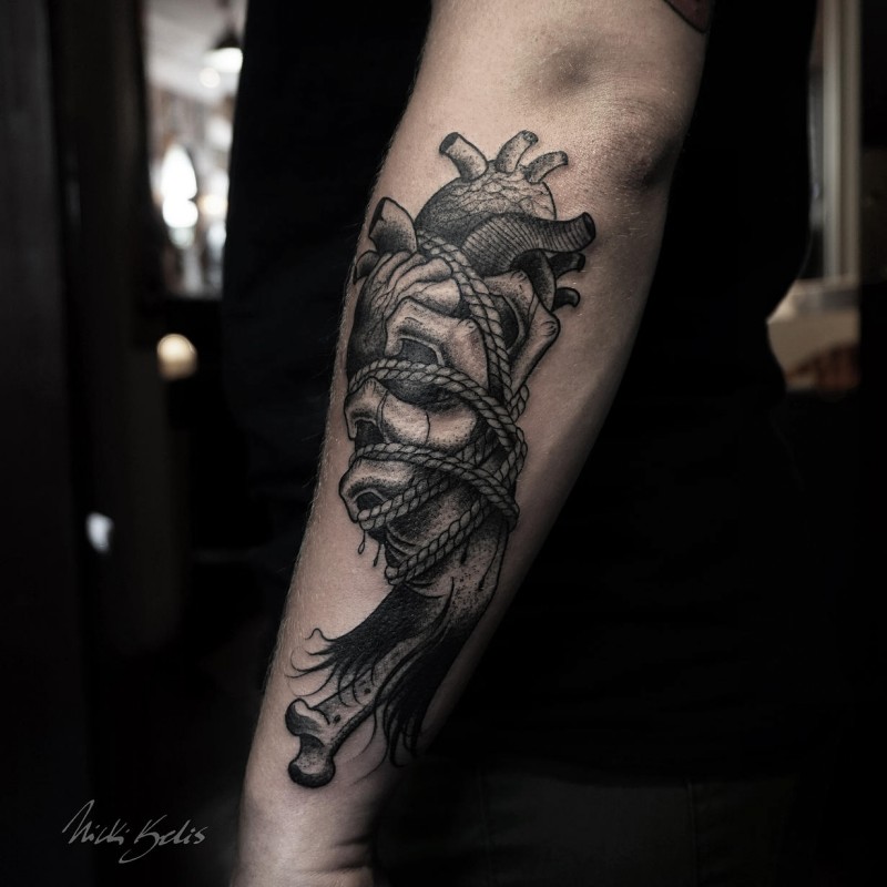 Engraving style black ink arm tattoo of human heart with bones and rope