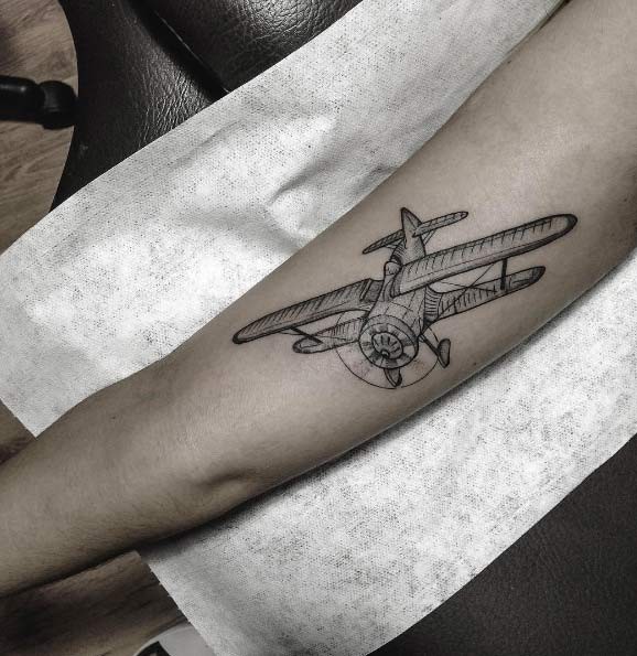 Engraving style black ink arm tattoo of small plane