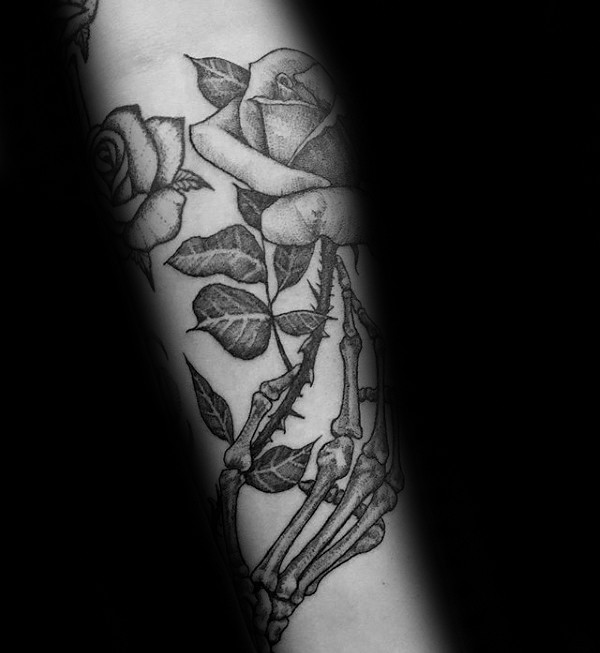 Engraving style black ink arm tattoo of rose with bone hand