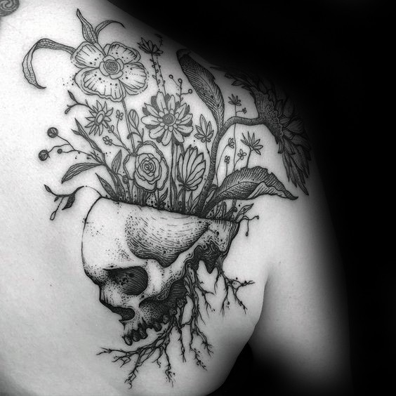 Engraving style black ink human skull tattoo on scapular stylized with various flowers