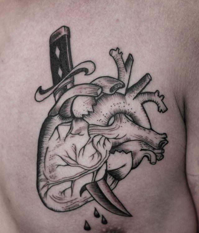 Engraving style black ink scapular tattoo of human heart with knife