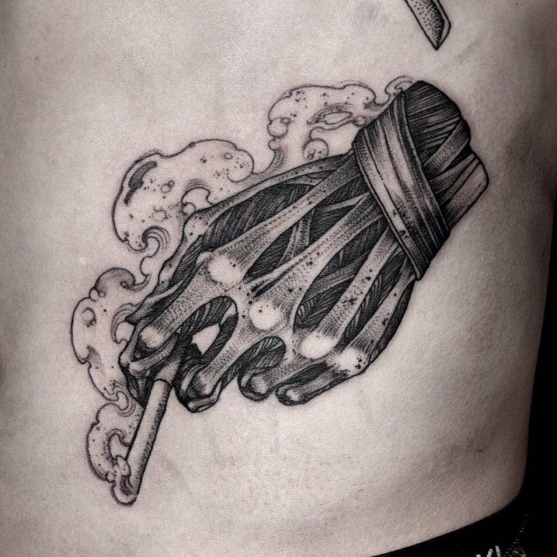 Engraving style black ink side tattoo of skeleton hand holding cigarette