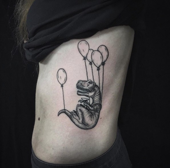 Engraving style black ink side tattoo of dinosaur with balloons