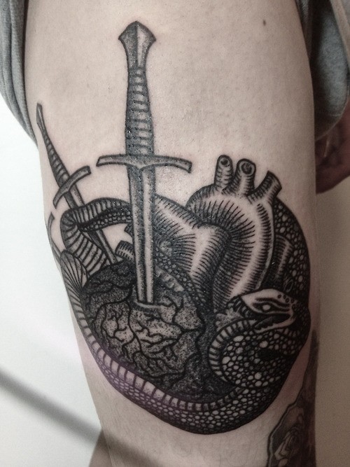 Engraving style black ink tattoo of human heart with swords and snake