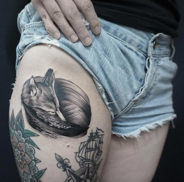 Engraving style black ink thigh tattoo of sleeping fox