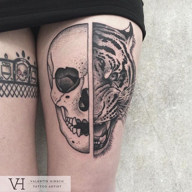 Engraving style black ink thigh tattoo of human skull with tiger head