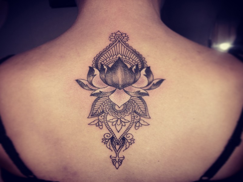 Engraving style black ink upper back tattoo of lotus flower with ornaments by Caro Voodoo