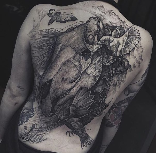 Engraving style black ink whole back tattoo of dinosaur skull with birds and butterfly