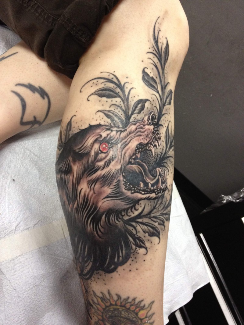 Engraving style colored leg tattoo of demonic wolf with plants