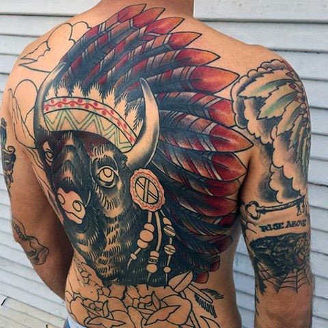 Enormous unfinished colored Indian bull with flowers tattoo on whole back