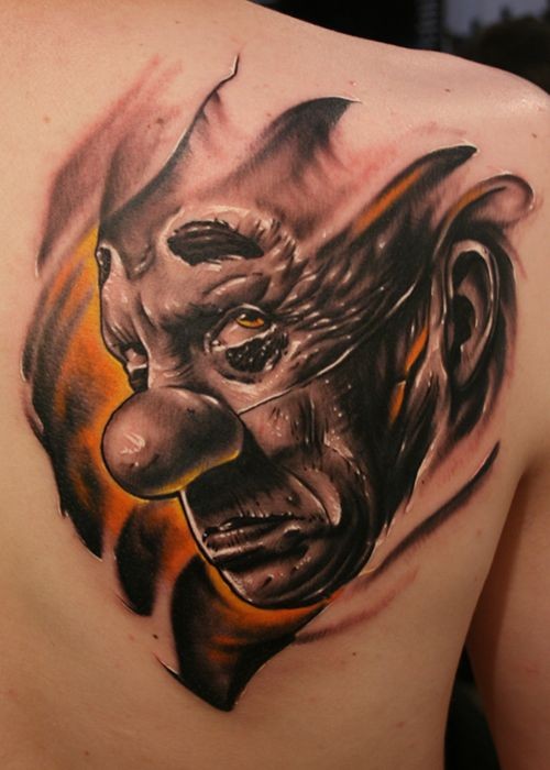 Evil clown tattoo on shoulder blade