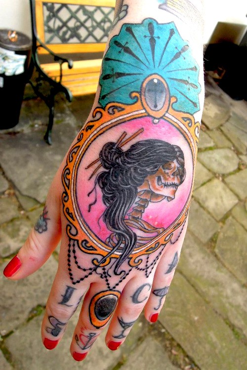 Tattoo von weiblichem bösem Totenkopf auf der Hand