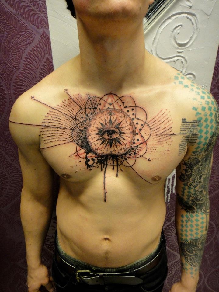 Tatuaje en el pecho de un ojo con un símbolo en el centro.
