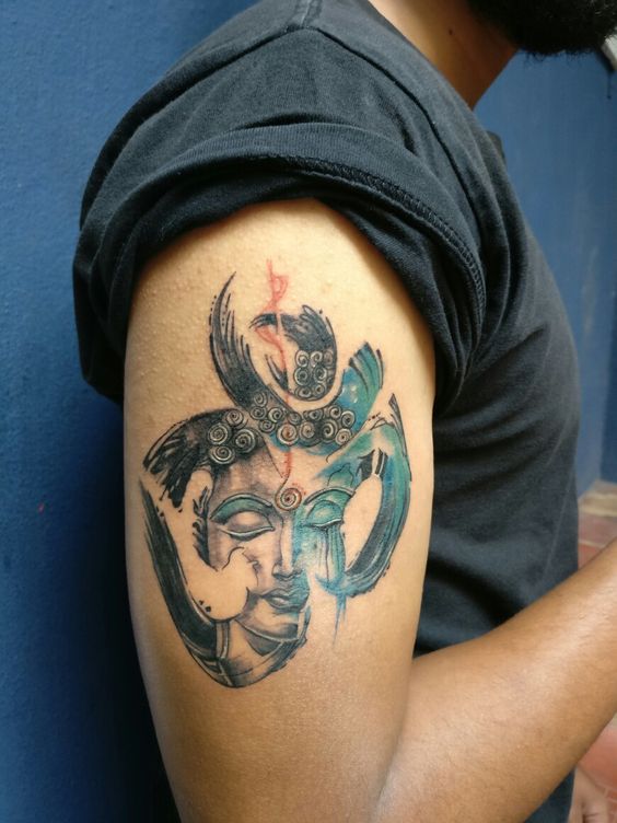 Face of a buddha in a hieroglyph tattoo on