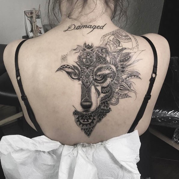 Fantástico olhando para trás tatuagem de cabeça de lobo estilizado com ornamentos e letras