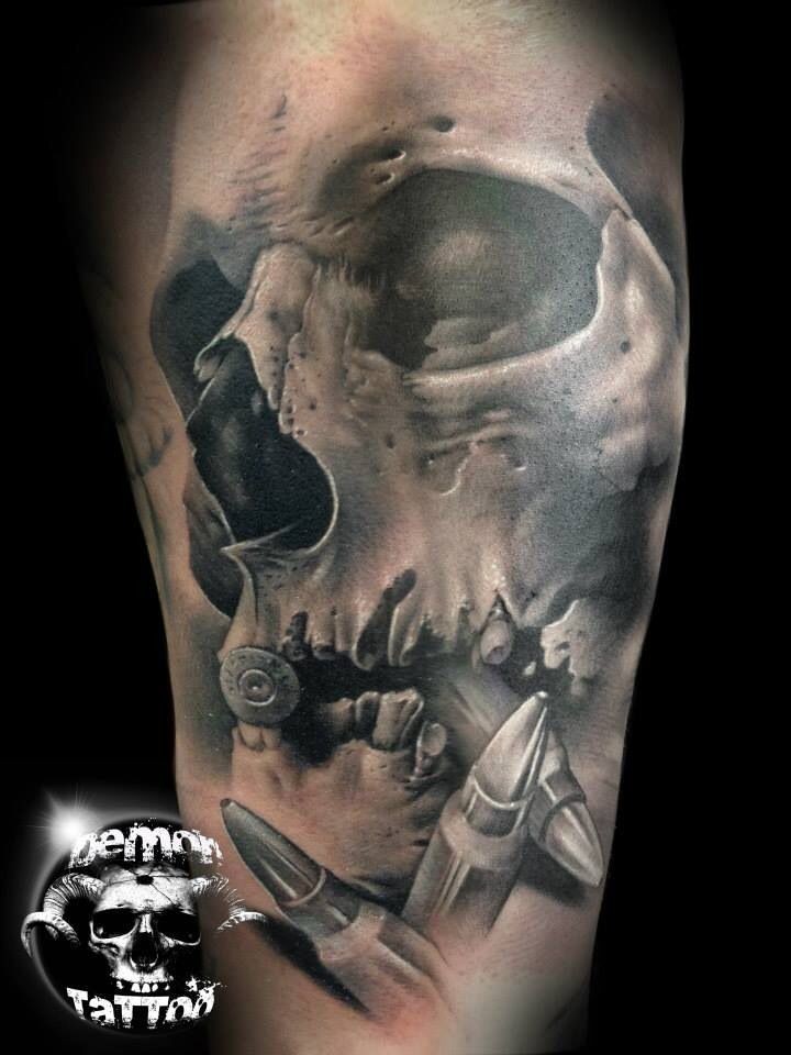 Fantastic painted very realistic black and white skull with bullets tattoo on arm
