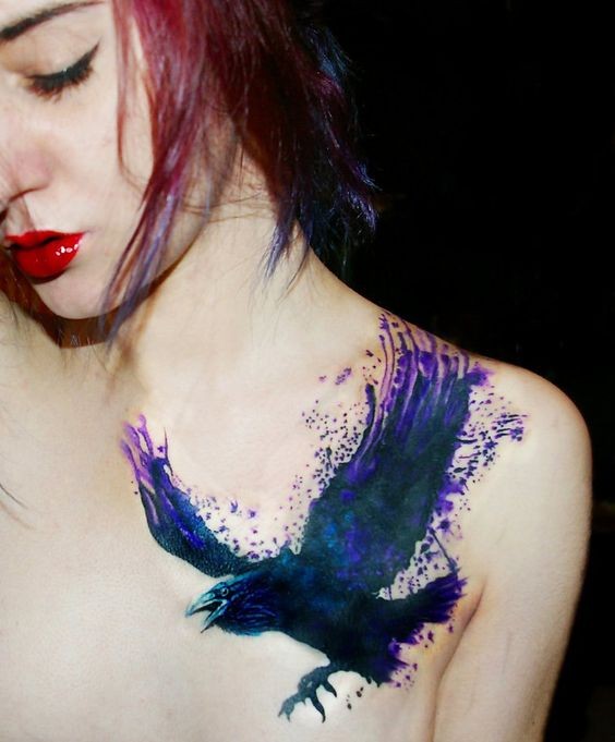 Fantastic watercolor like black and violet colored crow tattoo on shoulder