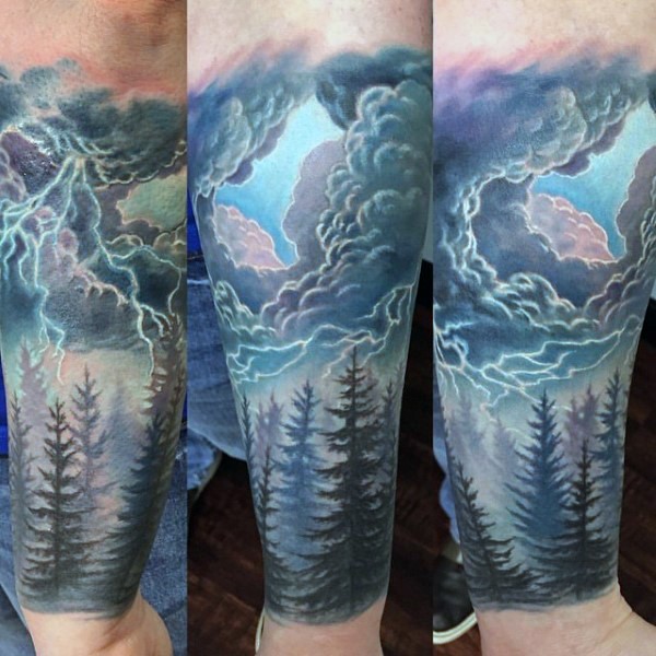 Fantasy like colored old forest with thunder clouds tattoo on arm