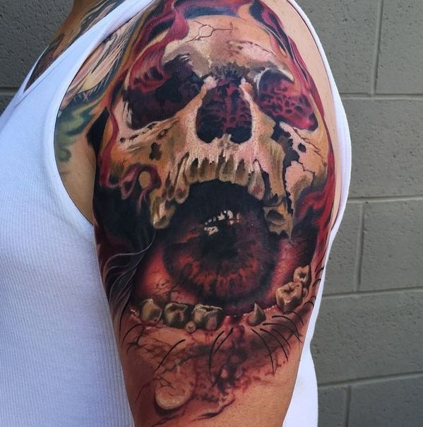 Fantasy style creepy looking shoulder tattoo of human skull stylized with eye