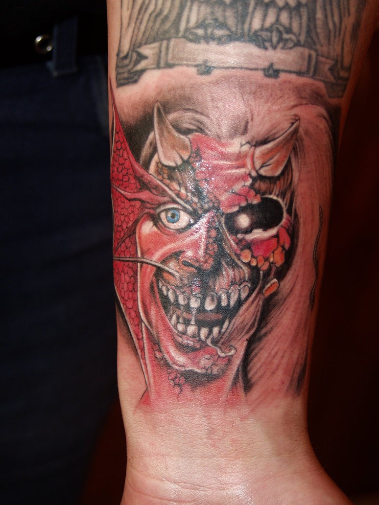 Tatuaggio colorato sul braccio la faccia del demone
