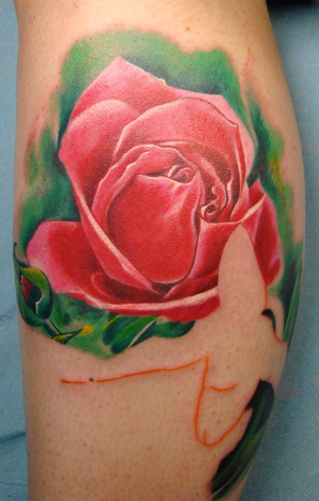 Tatuaggio sulla gamba la rosa rossa sul sfondo verde