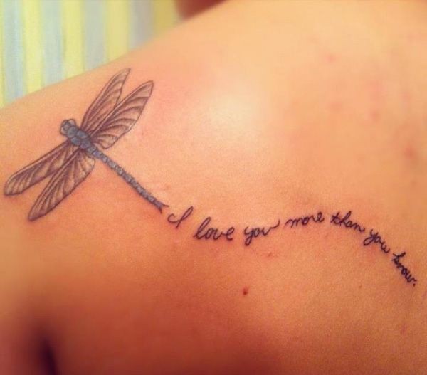 Flying dragonfly and inscription tattoo on shoulder blade
