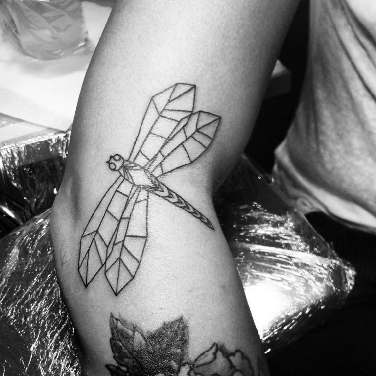 Flying dragonfly tattoo on arm in geometry style