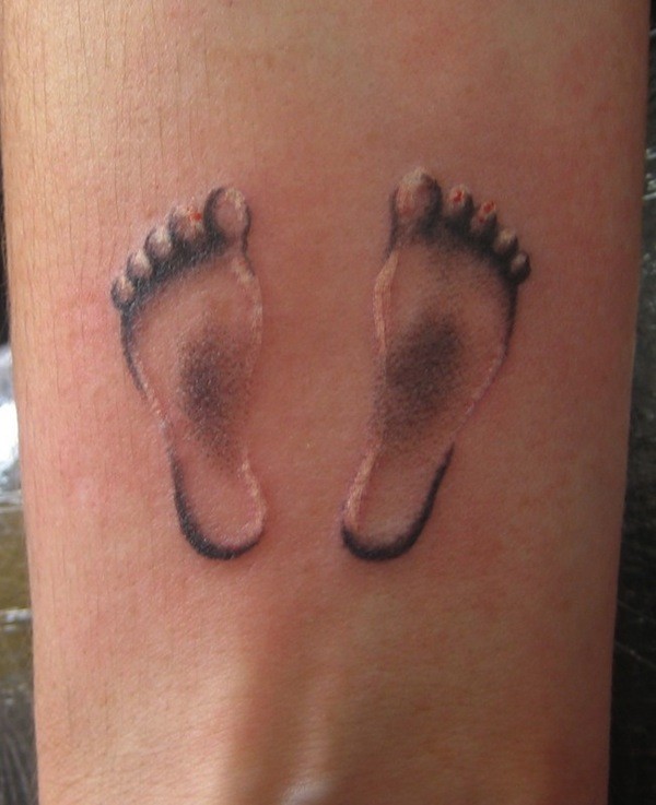 impronti di piedi bambino 3D tatuaggio su polso di uomo