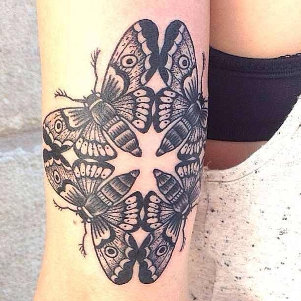 Four black and white moth tattoo